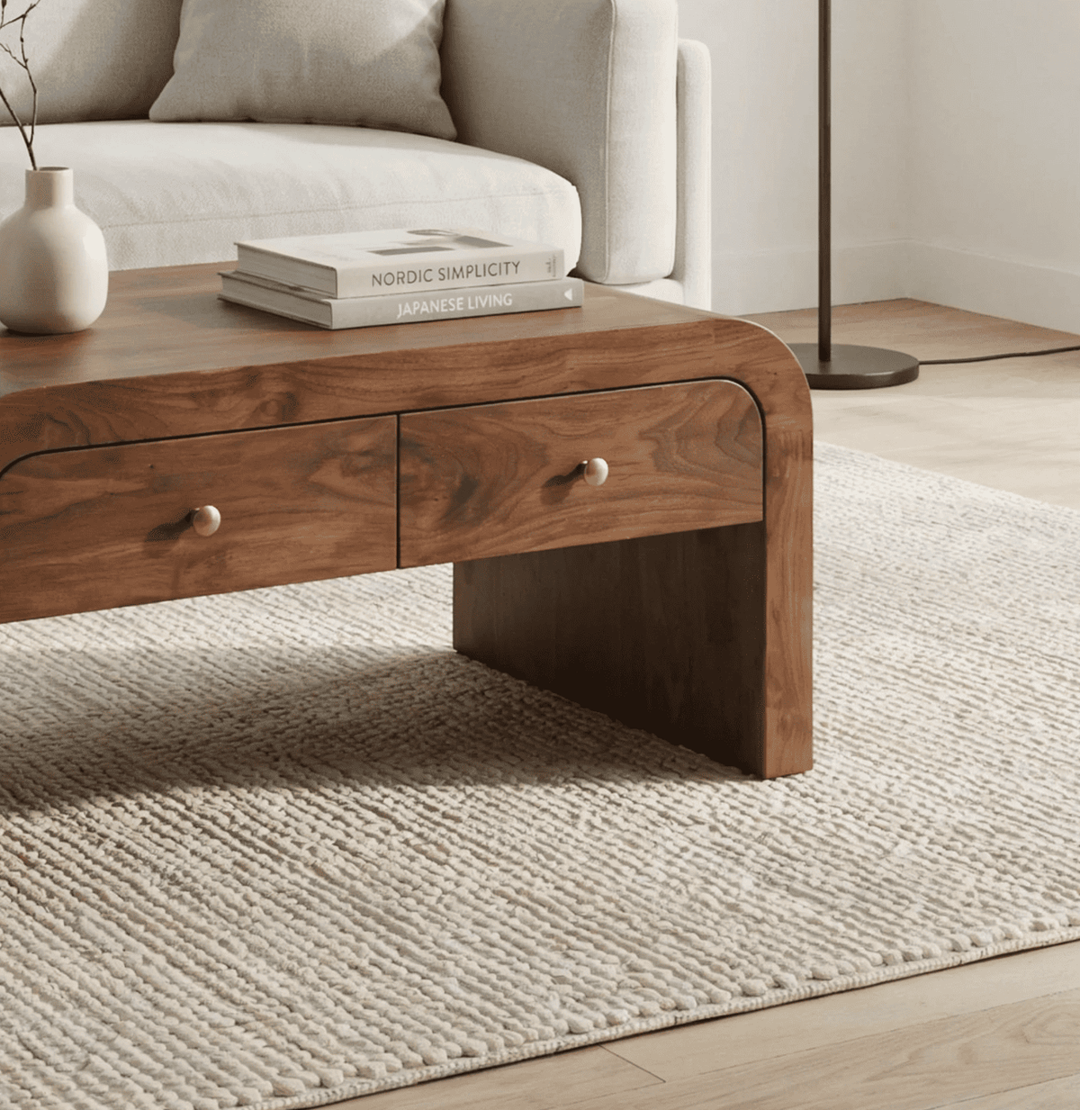 Sculptural curved coffee table crafted from solid wood with functional drawer storage