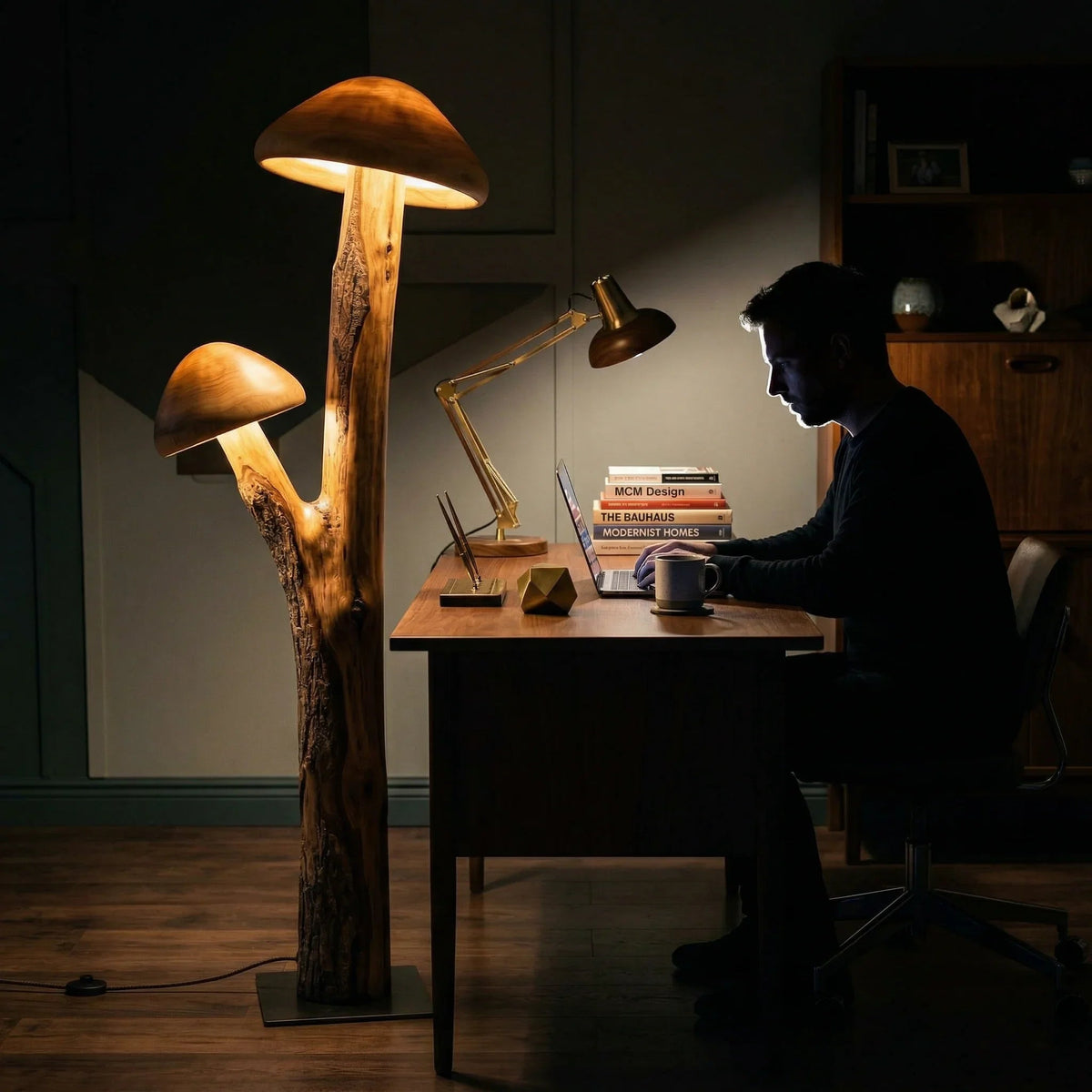 Dual mushroom-shaped wooden floor lamp with glowing caps beside a modern desk workspace.
