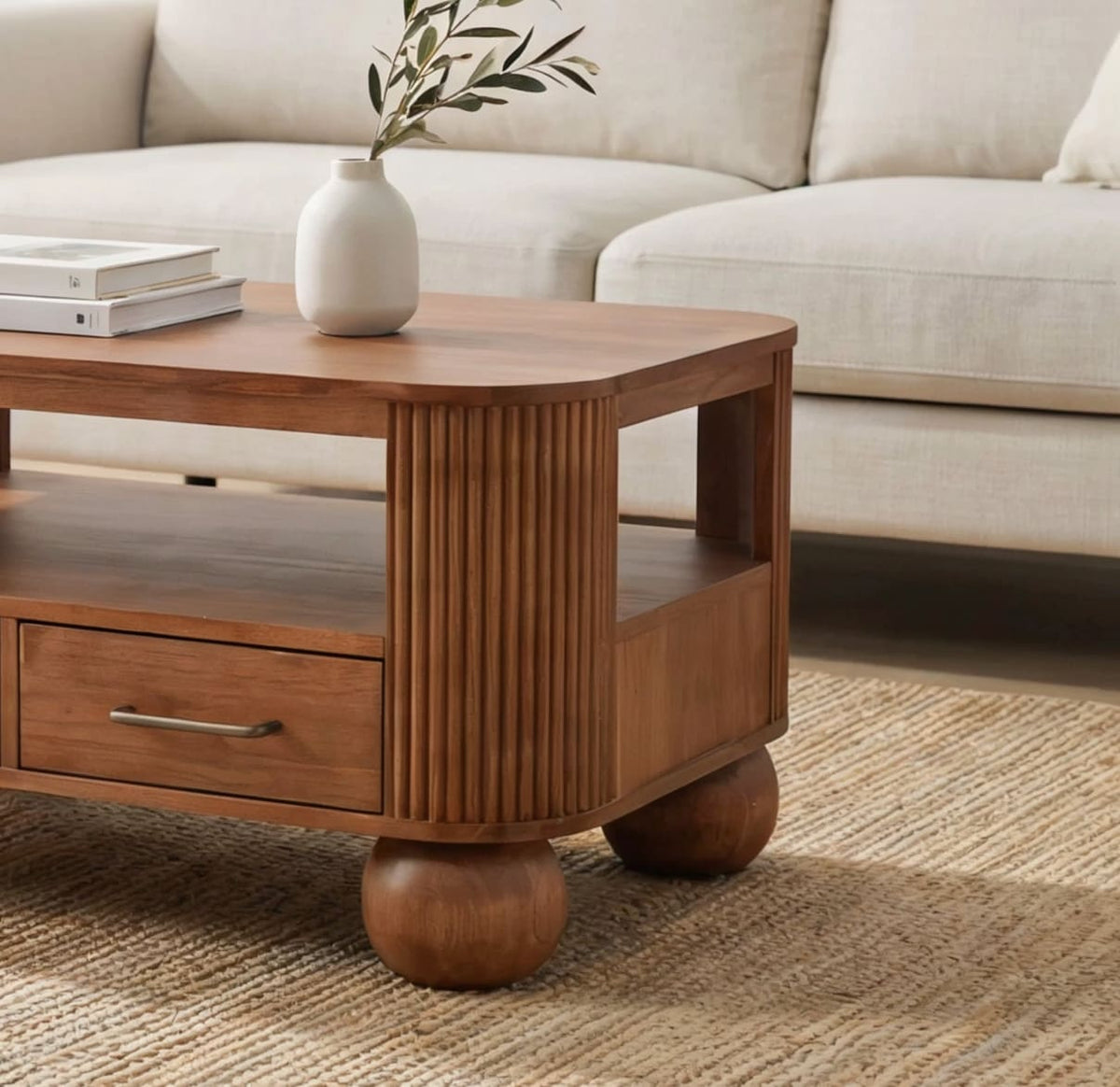Modern fluted solid wood coffee table featuring functional storage drawers and sculptural ball feet