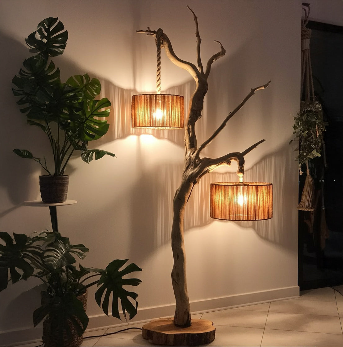 Rustic wooden floor lamp with two hanging drum shades next to potted monstera plants in cozy room