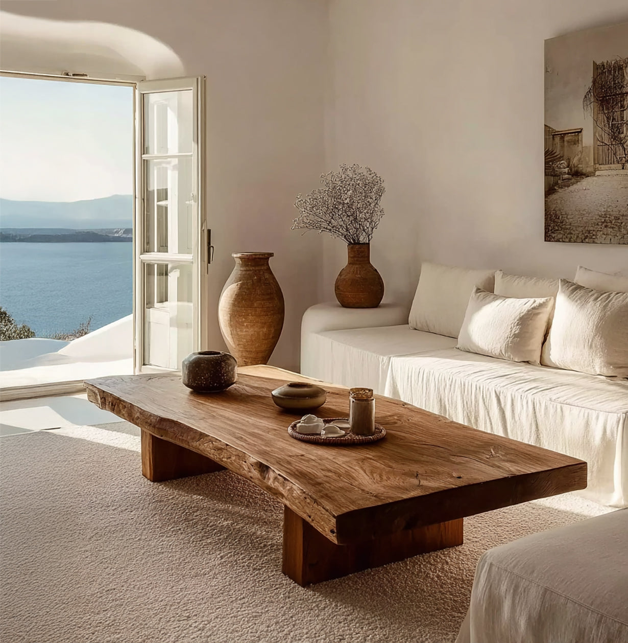 Cozy living room with natural wood coffee table, beige sofa, ceramics, and sea view through open door